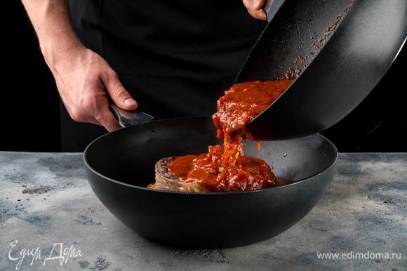 К овощам выложите стейки. Залейте все томатным соусом и готовьте до мягкости мяса.