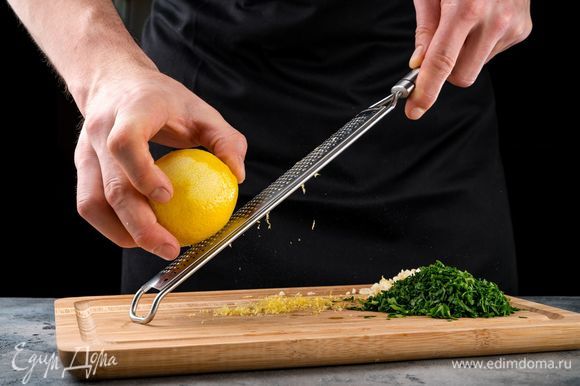Тем временем приготовьте гремолату. Для этого порубите петрушку мелко, натрите на терке лимонную цедру, измельчите чеснок. Все смешайте.