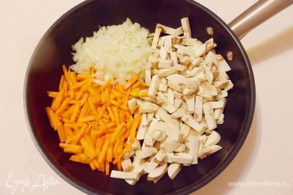 На разогретую и смазанную растительным маслом сковороду выложить лук, морковь и шампиньоны.