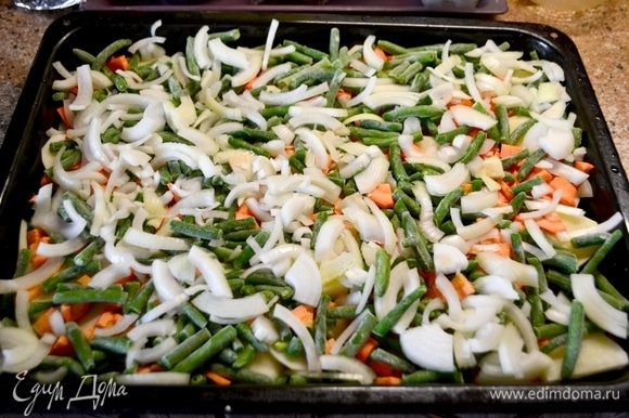Мясо (у меня часть свиного окорока) разрезать на порционные куски (не отбивать его), натрем солью и специями. Оставим мясо мариноваться, пока подготавливаем овощи. Овощи помыть почистить. Картошку нарезать кольцами, морковь нарезать кубиком, лук нарезать полукольцами. Выложить овощи в форму, смазанную маслом. 1-й слой — картошка. 2-ой слой — морковь. 3-й слой — зеленая фасоль. 4-й слой — лук.