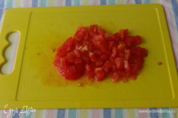 Тонким острым ножом снять кожицу с помидора и нарезать его кубиками.