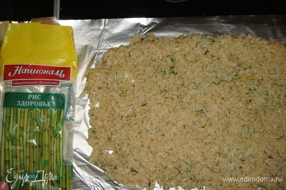 К рису добавить яйцо и мелко порубленную зелень. Хорошо все перемешать. Выложить рис на фольгу и разровнять ложкой.