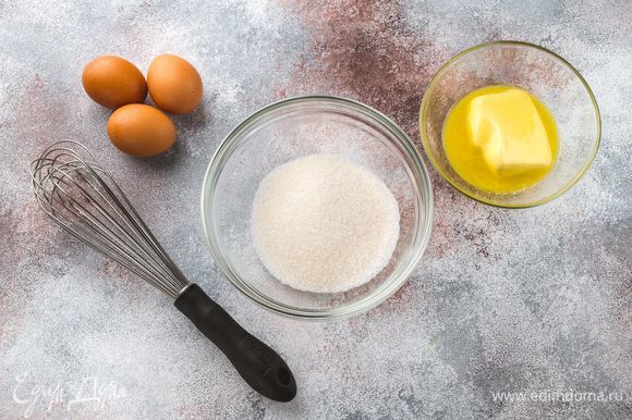 Взбейте куриные яйца с сахаром до образования пышной белой пены. Удобным способом растопите сливочное масло, остудите.