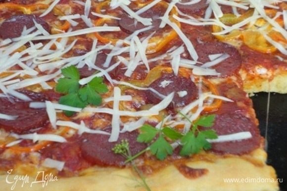 Готовую пиццу посыпаем тертым пармезаном и листочками базилика или любимой зелени (у меня это кинза).