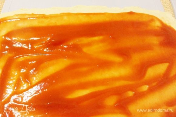 Слоеное тесто разморозить естественным путем. Раскатать в пласт толщиной около 4 мм. Смазать поверхность кетчупом.