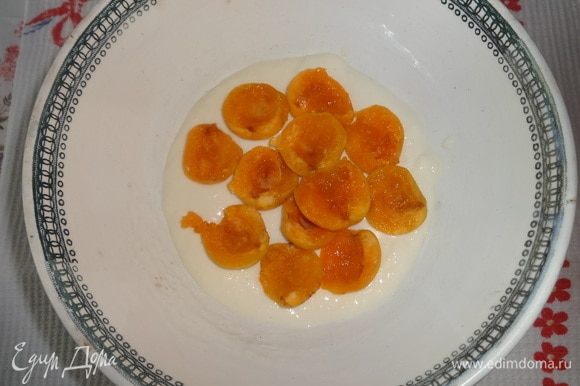 В чашку с шарообразным дном положить немного желейной массы. Выложить слой абрикосов срезом вверх.