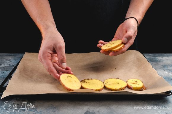 Противень выстелите пергаментом, выложите на него кружочки картофеля. Запекайте в заранее разогретой до 200°С духовке 15 минут.