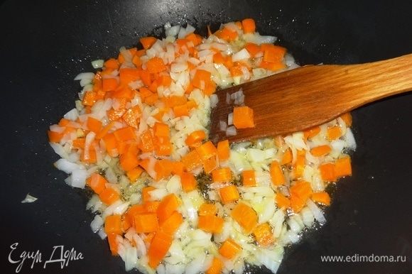 В сковороду налить масло для риса и овощей, разогреть его. Положить лук и морковь, обжарить, помешивая, до золотистого цвета.