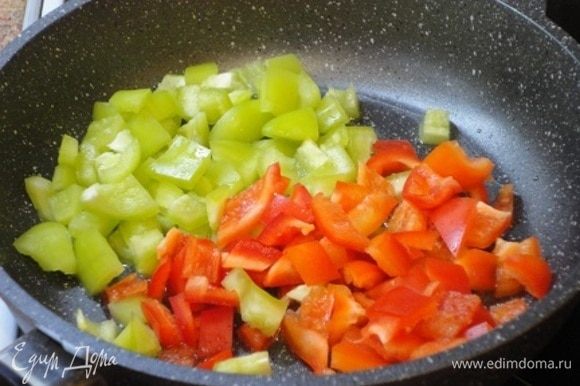 В это время готовим овощи. Красный и зеленый перей нарезаем мелкими кубиками и жарим 3–4 минуты.