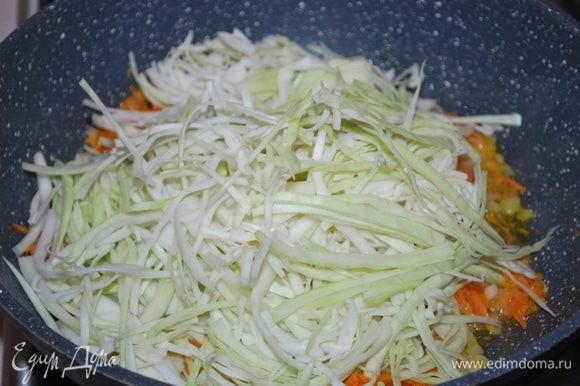 К обжаренной моркови с луком добавляем нарезанную капусту и обжариваем все вместе 5–7 минут.