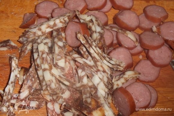 Нарезать любую копченую колбасу. Отправить вместе с мясом в бульон.