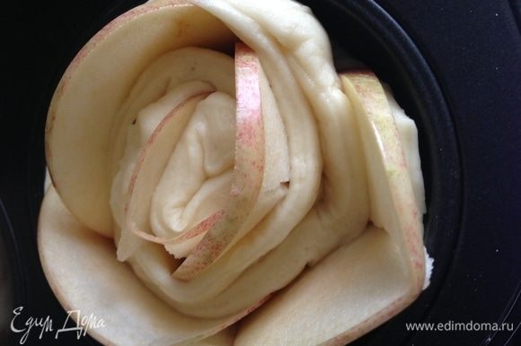 Посыпать яблоки смесью сахара и корицы. Свернуть тесто с яблоками в рулет и выпекать в форме для маффинов при 170°C до готовности.