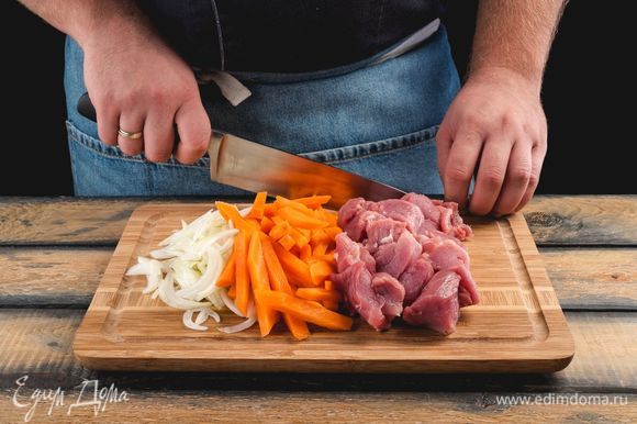 Нарежьте мясо ломтиками, морковь — крупной соломкой, а лук — полукольцами.