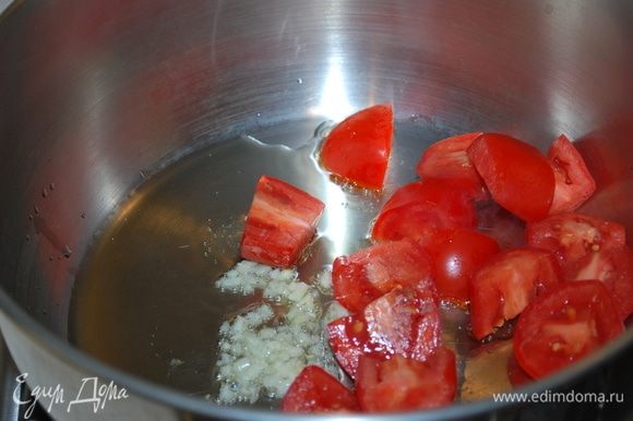 Нагреем масло в большой сковороде и обжарим чеснок, затем добавим помидоры, потушим пару минут.