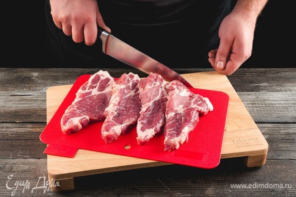 Нарежьте свинину крупными кусочками толщиной 1,5–2 см, используя разделочную доску Faberlic by Julia Vysotskaya. Натрите мясо солью и перцем.