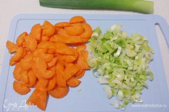 Промыть морковь и лук-порей. Нарезать овощи тонкими полукольцами.
