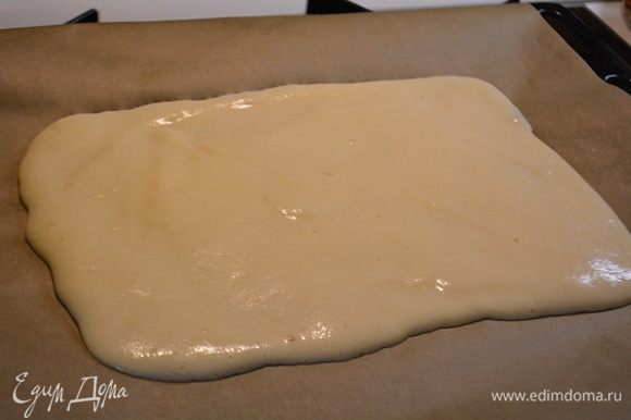 Вылить тесто на противень, выстланной пекарской бумагой. Разровнять, чтоб получился прямоугольник. Запечь при температуре 180°C в течение 15 минут.