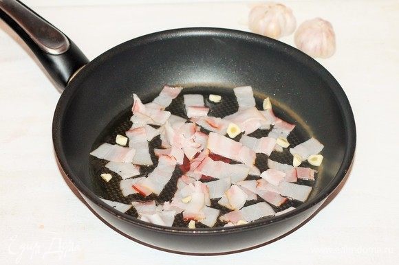В большой сковороде разогреть масло, выложить нарезанный бекон (4 пластины) и очищенный порубленный чеснок, жарить, помешивая, около 2 минут.