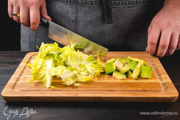 Мякоть авокадо и салатные листья нарежьте, сбрызните лимонным соком и перемешайте.