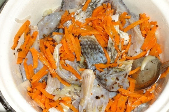 Достать рыбу из холодильника. Отлить половину маринада, он больше не понадобится. Добавить к рыбе с луком морковь с пряностями, перемешать и поставить в холодильник еще на пару часов.