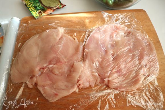 Поместить филе куриных грудок между листами пищевой пленки, отбить аккуратно, стараясь не порвать кусочки филе.
