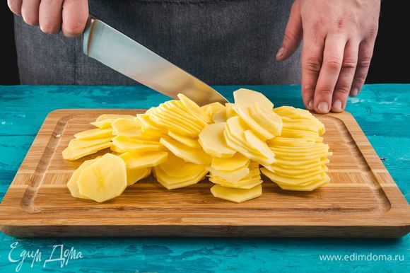 Разогрейте духовку до 220°С. Почистите картофель, нарежьте тонкими кружочками.