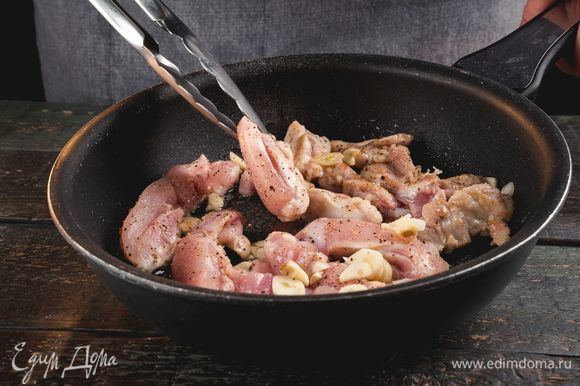 Нарежьте филе тонкими полосками, чеснок раздавите или мелко нарежьте. Выложите мясо с чесноком на разогретую сковороду, посолите по вкусу, обжаривайте 5–7 минут.