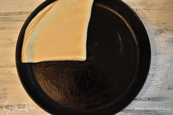Чтобы тесто легче было перенести на сковороду, складываю его пополам и потом еще раз пополам. Переношу на сковороду, смазанную растительным маслом. Верх получившегося треугольника из теста укладываю в центр и разворачиваю тесто, придавая первоначальную форму.
