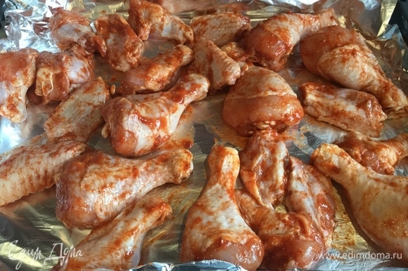 Выложить курицу на противень и готовить в предварительно нагретой духовке на режиме «Гриль» при температуре 180°C.