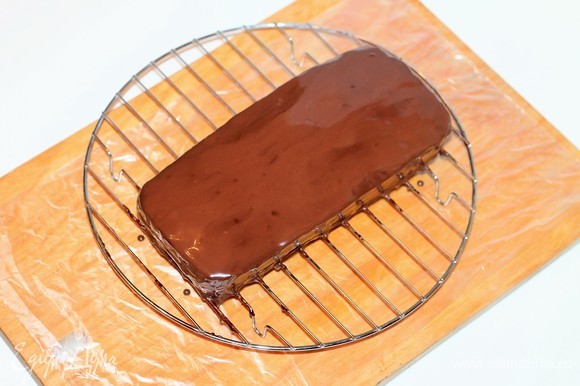 Выложить охлажденный торт на решетку и полить горячим шоколадом. Отправить торт в холодное место до застывания шоколада.
