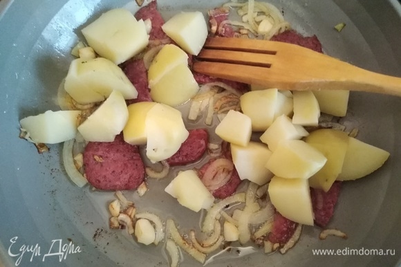Вареный картофель нарезать крупными кубиками и добавить в сковородку. Аккуратно перемешать.