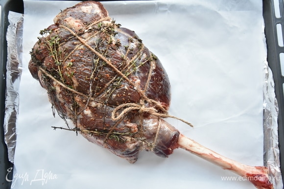 Сверху на мясо выложить веточки тимьяна или розмарина. Выложить ногу на противень. Запекать мясо в разогретой до 180–190°C духовке в течение 1 часа.