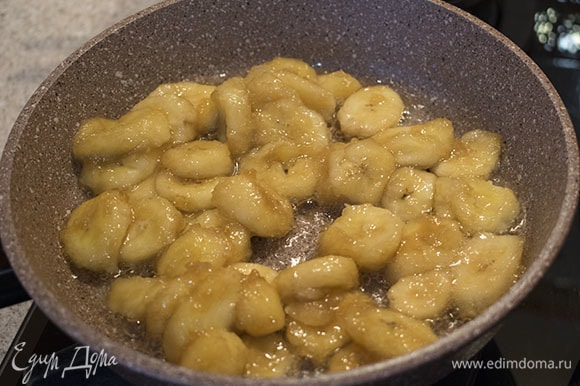 Когда начнут появляться пузырьки, добавить в сковороду бананы, перемешать и жарить 3–4 минуты на среднем огне, пока бананы не станут красивого золотистого цвета.