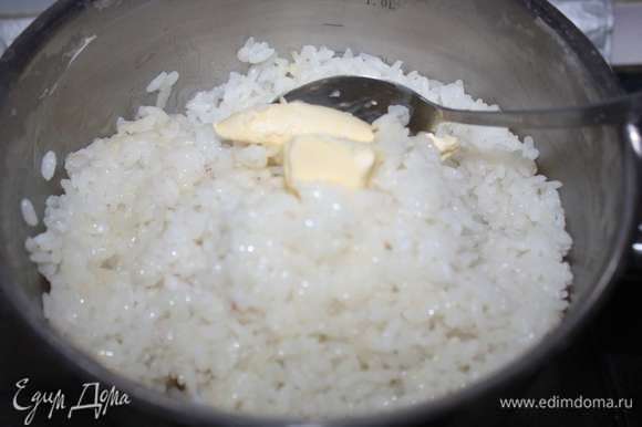 В горячий рис добавим сливочное масло и аккуратно перемешаем.