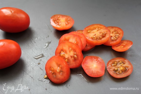Нарезать слайсами помидоры черри.