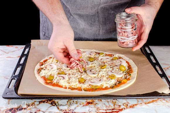 Щупальца кальмаров ТМ «Капитан Вкусов» процедите от жидкости, выложите на пиццу.