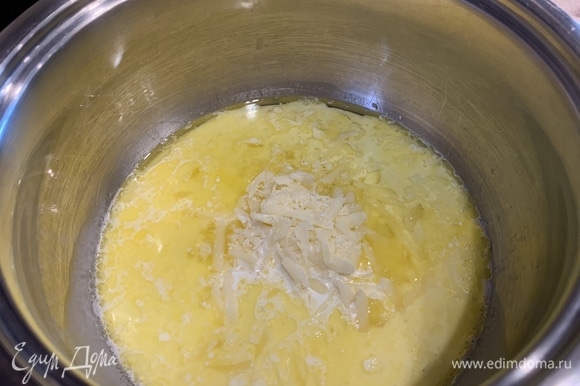 В растопленное масло влить сливки, добавить натертый твердый сыр, посолить и перемешать.