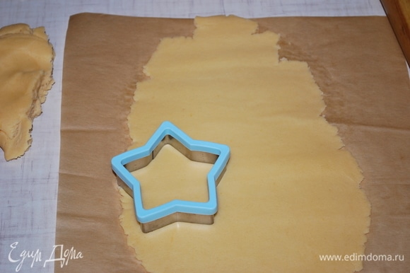 Раскатайте тесто на бумаге для выпечки, формочкой вырежьте фигурки.