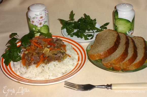 На тарелку выложить порцию риса, сверху положить куриные желудки с овощами, украсить зеленью и подать к столу. Приятного аппетита!