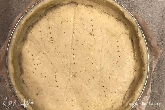 Переложить тесто в форму диаметром 20 см и наколоть его вилкой.