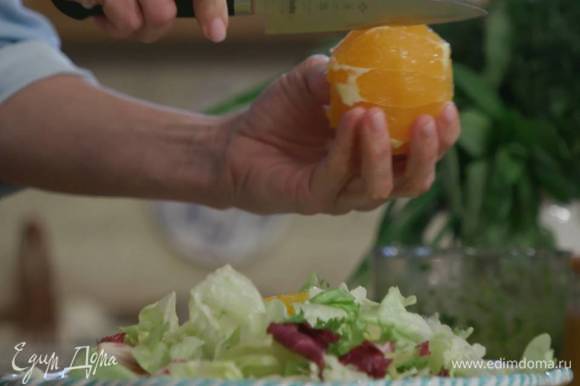С апельсина срезать кожуру и над салатными листьями вырезать из перепонок мякоть.