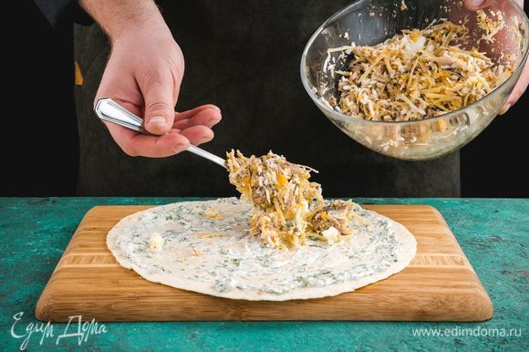 Разложите тортилью, смажьте майонезом с чесноком и зеленью. Сверху выложите начинку из сайры с яйцом и сыром.