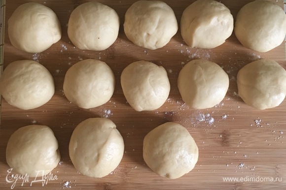 Когда тесто подойдет, разделить его на небольшие шарики примерно по 70–80 г (получилось 13 булочек), накрыть пищевой пленкой, чтобы не заветривались.