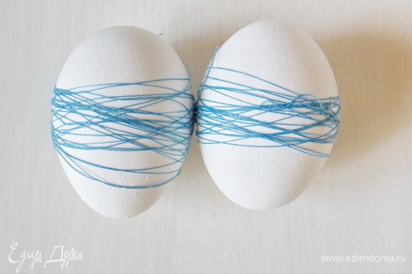 Для первого узора плотно обмотайте яйца ниткой для шитья.