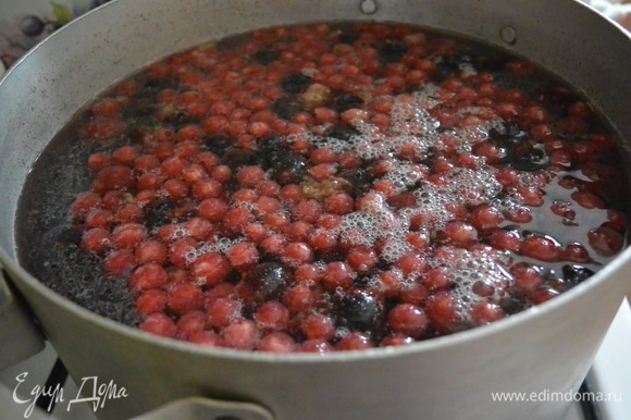 Замороженные ягоды отправляем в кипящую воду и снова ждем, пока вода закипит, уменьшаем огонь. Убираем пенку с поверхности.