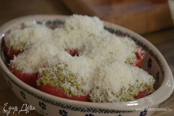 Выложить помидоры в жаропрочную керамическую форму, наполнить начинкой и посыпать натертым сыром.
