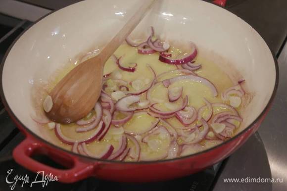 Разогреть в сковороде с жаропрочной ручкой оливковое масло и обжарить лук и чеснок.