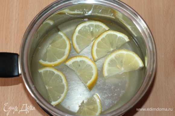 Из воды (1 литр) и сахара сварить сироп, постоянно помешивая. В кипящий сироп выложить дольки лимона и снять с огня.