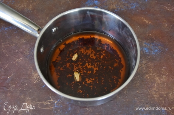 Зерна кардамона раздавить ножом и добавить в сотейник с чаем. На медленном огне дать покипеть чаю 1 минуту.