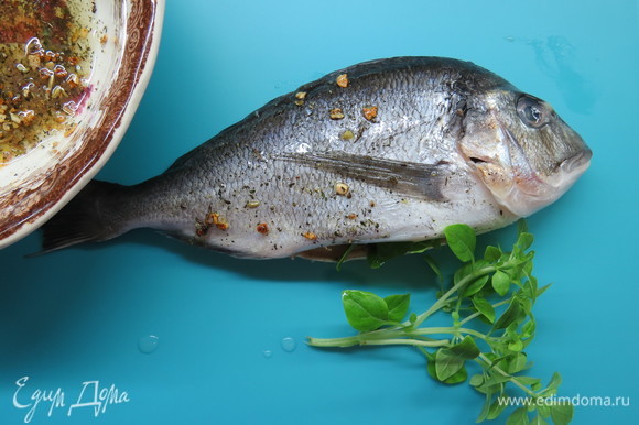 У рыбы удалить жабры и внутренности из брюшка, натереть полученным маринадом снаружи и внутри. В брюшко вложить дольку лайма и веточку базилика. Оставить на полчаса.